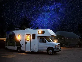 Erleuchtetes Wohnmobil vor Sternenhimmel